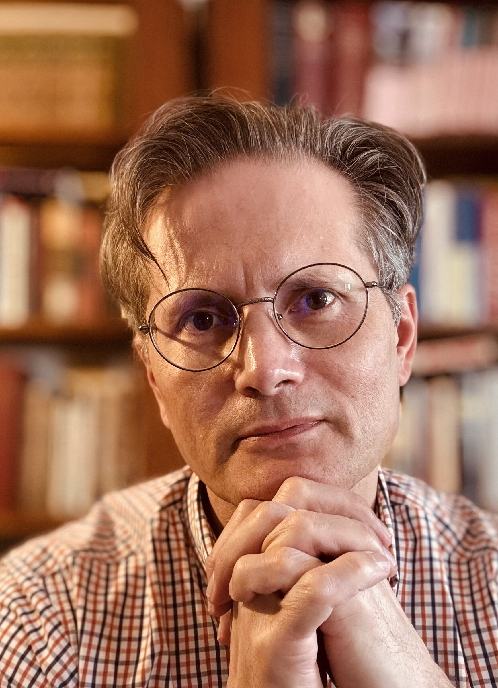 Formal portrait of Daniel E. Holloway in front of bookshelves