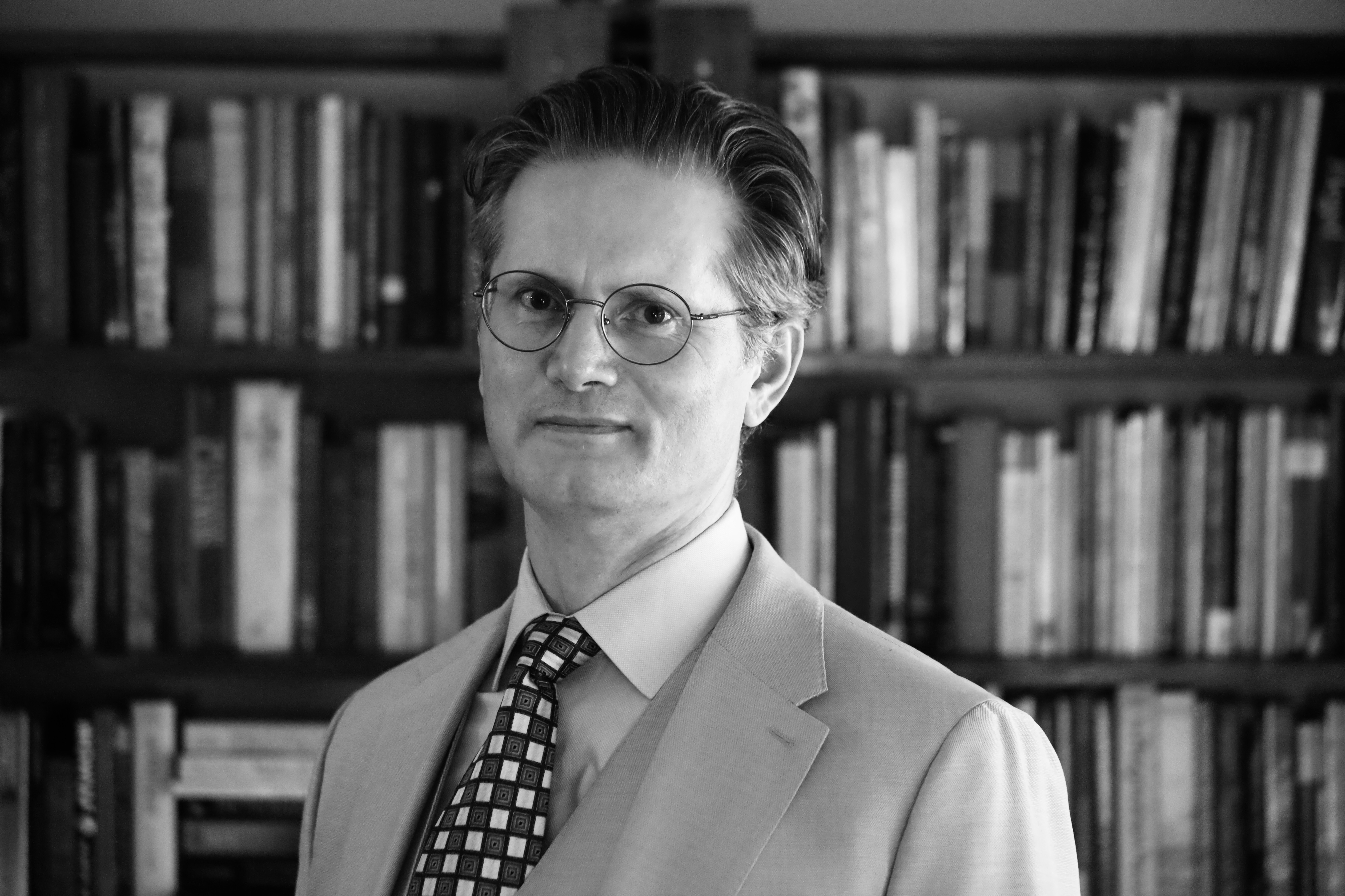 Daniel E. Holloway in front of bookshelves